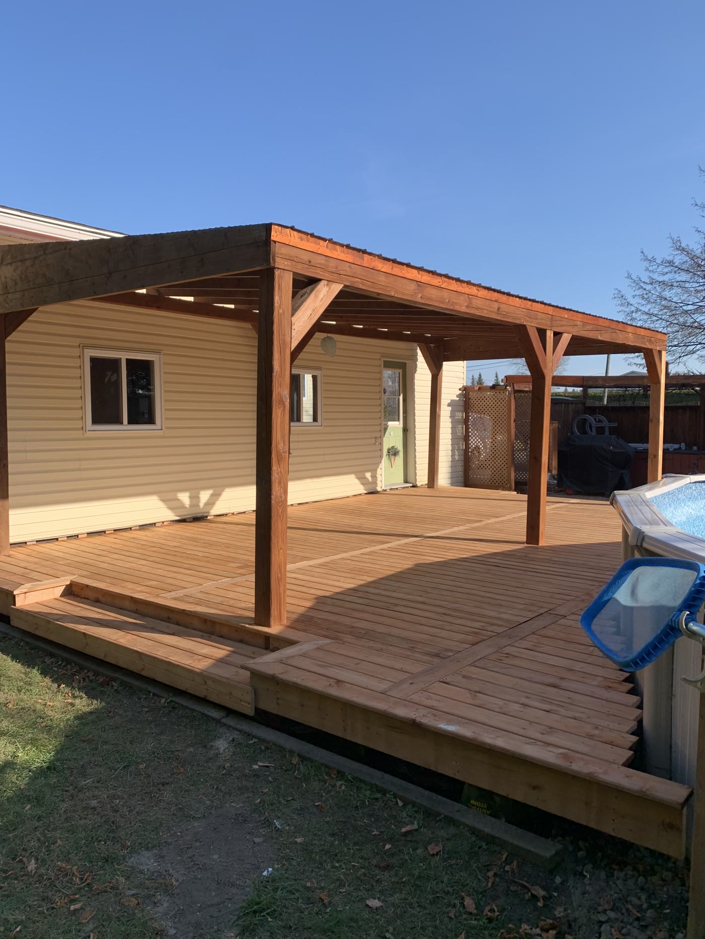 Toit couvert en bois au-dessus d'un grand deck avec piscine